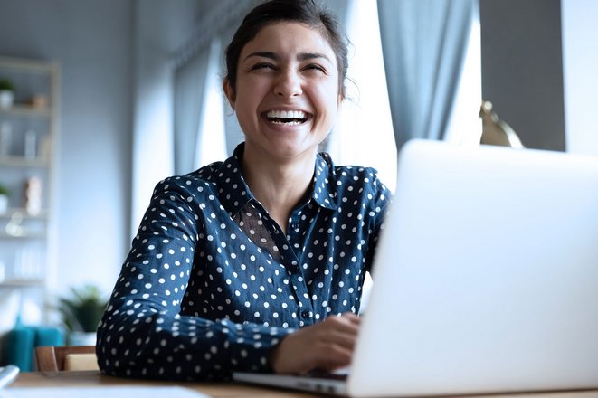 Foto einer freundlichen jungen Frau am Laptop